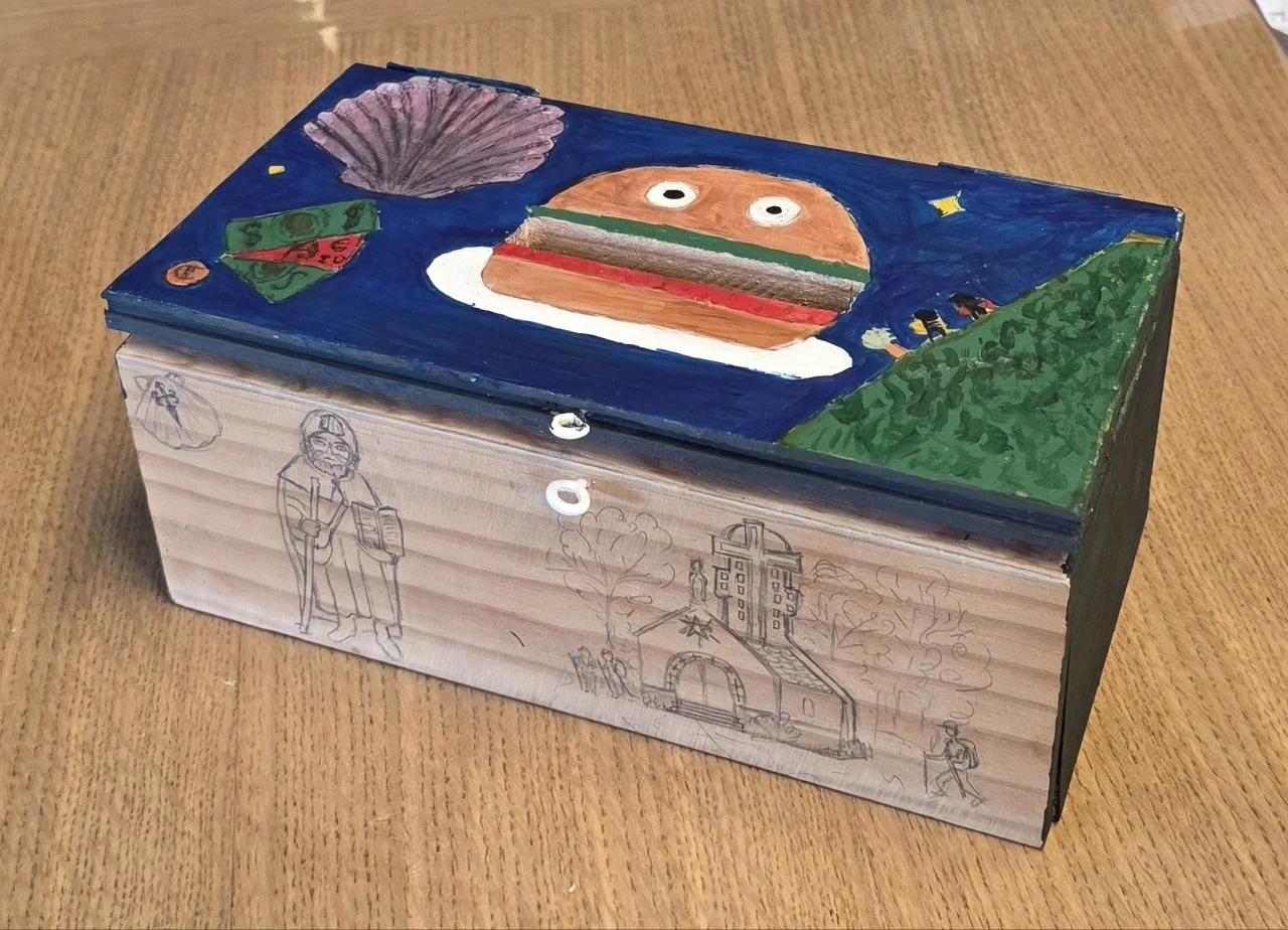 Boîte en bois peinte à la main : coquille Saint‑Jacques violette, sandwich coloré, paysage vert sur fond bleu nuit.